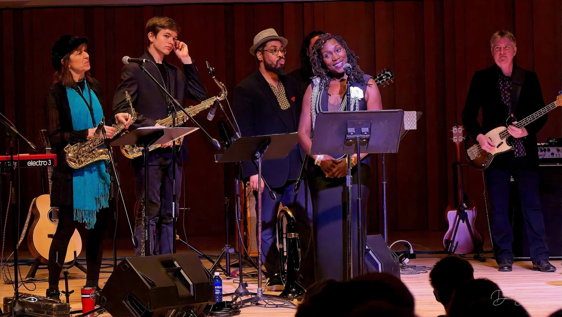 Vocalists and musicians performing under stage lighting at a United GA Entertainment event.